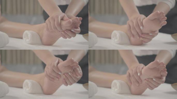 专业治疗师为水疗中心的女性提供传统的泰式足部按摩