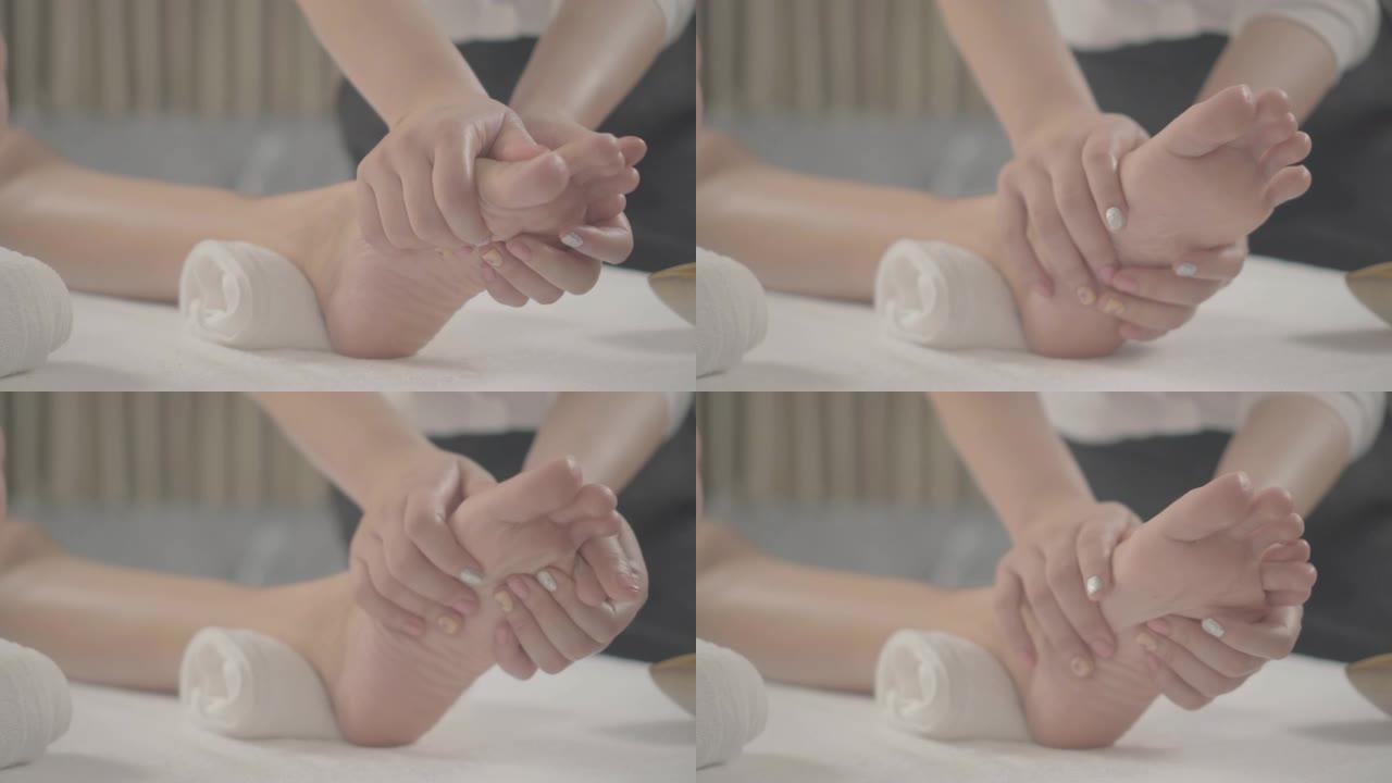 专业治疗师为水疗中心的女性提供传统的泰式足部按摩
