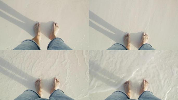 MS个人观点赤脚男子站在白色沙滩上的海浪中