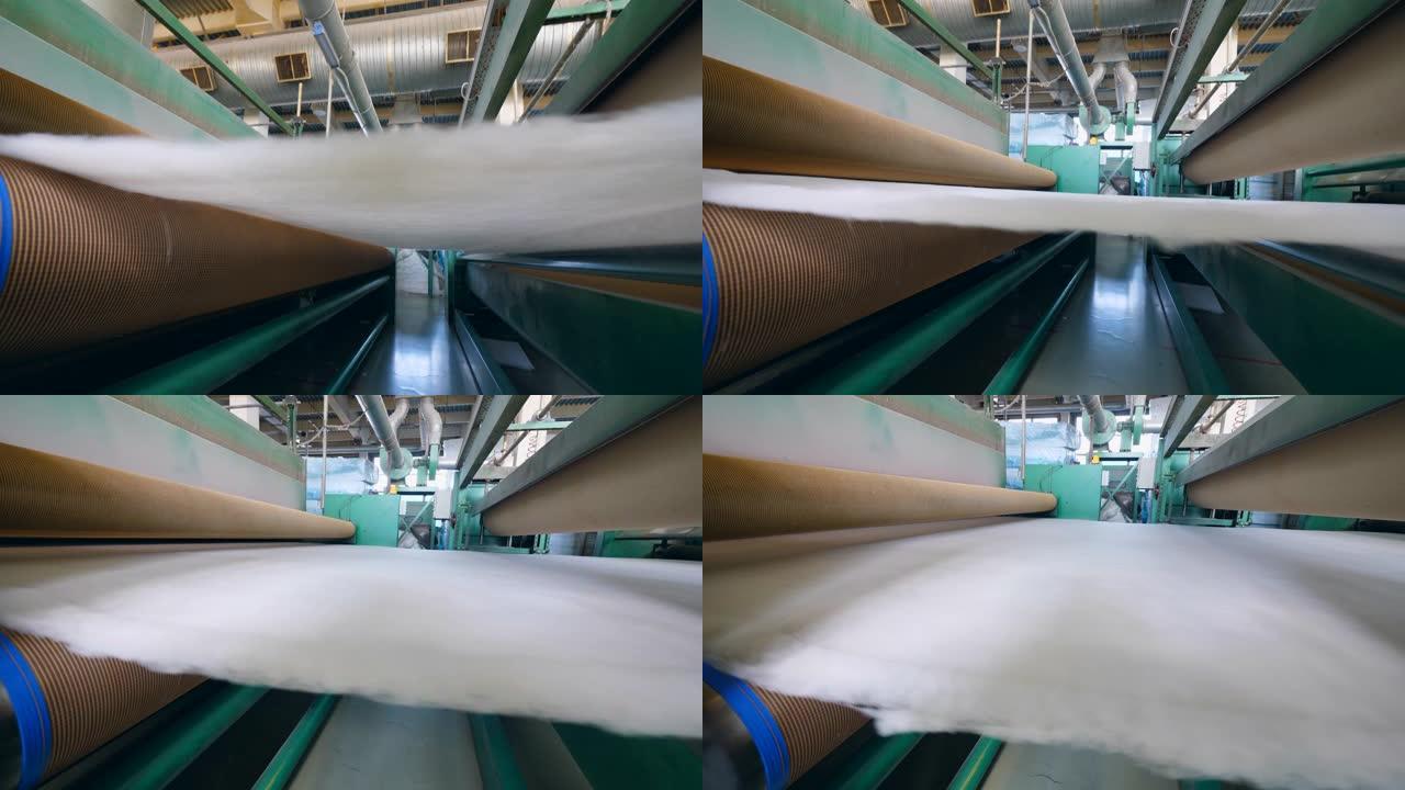 工厂滚筒移动一层白色合成织物。