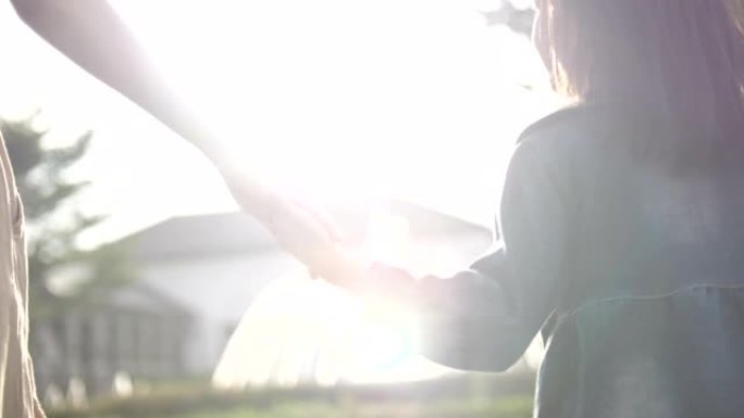 日落时，女人带着她迷人的小女儿在户外散步