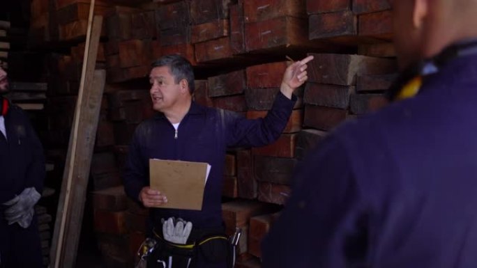 拉丁美洲经理指示他的团队在剪贴板上查看文档时指向木材的木材