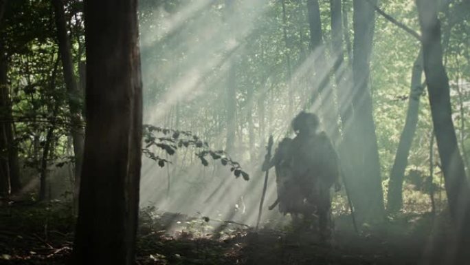 狩猎采集者部落戴着动物皮，拿着石尖工具，探索史前森林，寻找动物猎物。尼安德特人家庭在丛林中狩猎或迁移