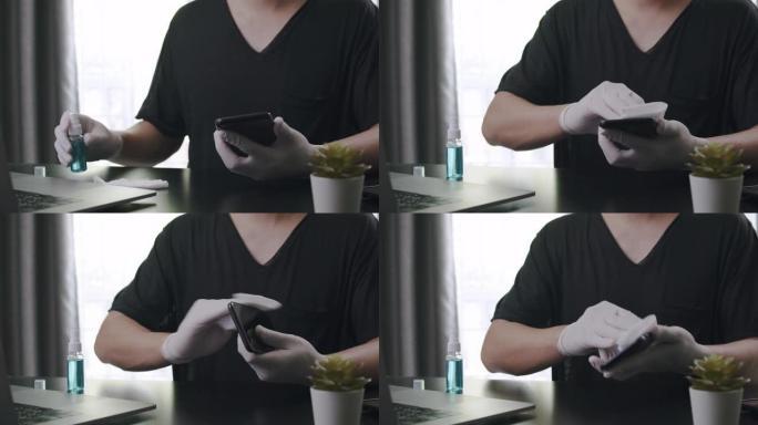亚洲男子使用消毒湿巾清洁他的智能手机或移动设备的屏幕，以清洁和抗菌冠状病毒或新型冠状病毒肺炎问题在家