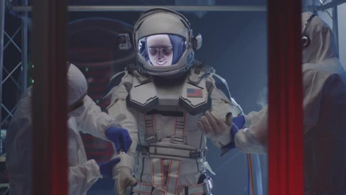 科学家帮助宇航员戴上手套