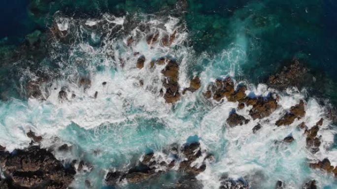 海洋冲浪。波浪在石头上破碎。海浪起泡和飞溅的海浪。空中俯视图。西班牙特内里费岛。4K, UHD
