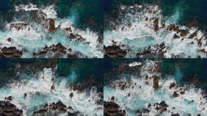 海洋冲浪。波浪在石头上破碎。海浪起泡和飞溅的海浪。空中俯视图。西班牙特内里费岛。4K, UHD