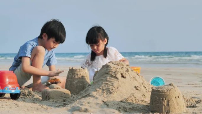 孩子们在海滩上玩沙箱。快乐的家庭在海滩上享受暑假。夫妻关系。假期-iStock