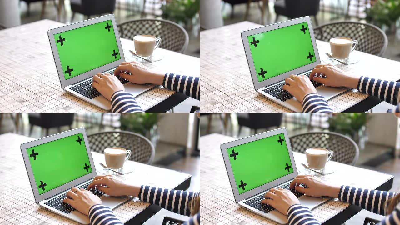 在咖啡馆使用带有绿屏的笔记本电脑的特写女人