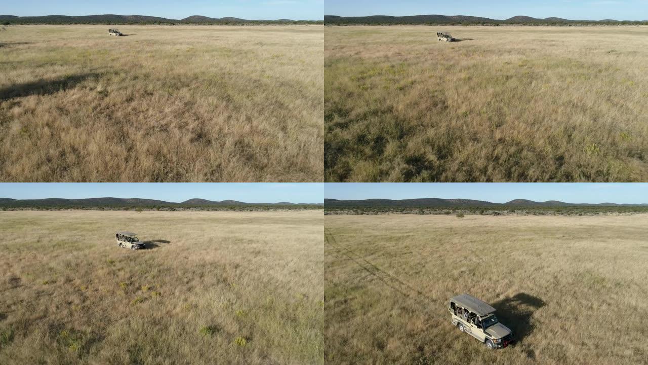 4k空中飞越行驶在纳米比亚非洲萨凡纳草原上的野生动物园车辆