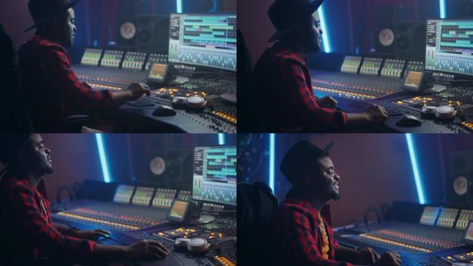 时尚的音频工程师/制作人在音乐录音室工作，使用混音板和软件来创建热门歌曲。富有创造力的黑人艺术家音乐