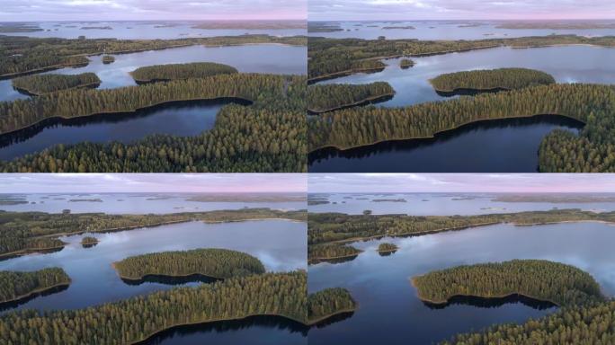 日落后神话般的芬兰莱克兰。摄像机在水和森林上方移动。紫色的天空在湖中反射。空中射击，4K