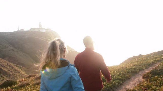 高年级高加索夫妇在山顶徒步旅行，太阳耀斑