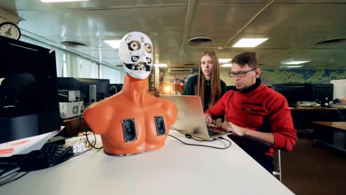 年轻的工程师正在操纵机器人移动其面部器官