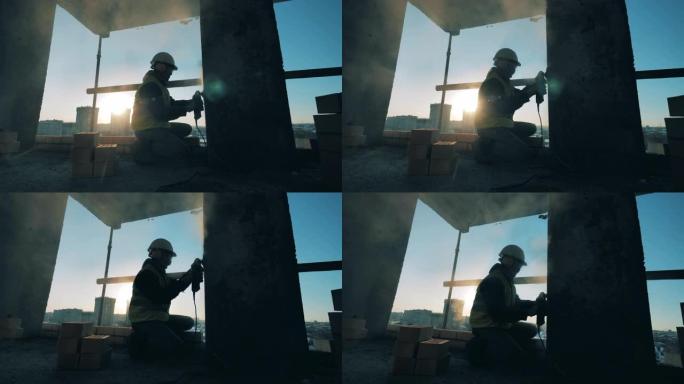 工人在墙上使用砂光机。