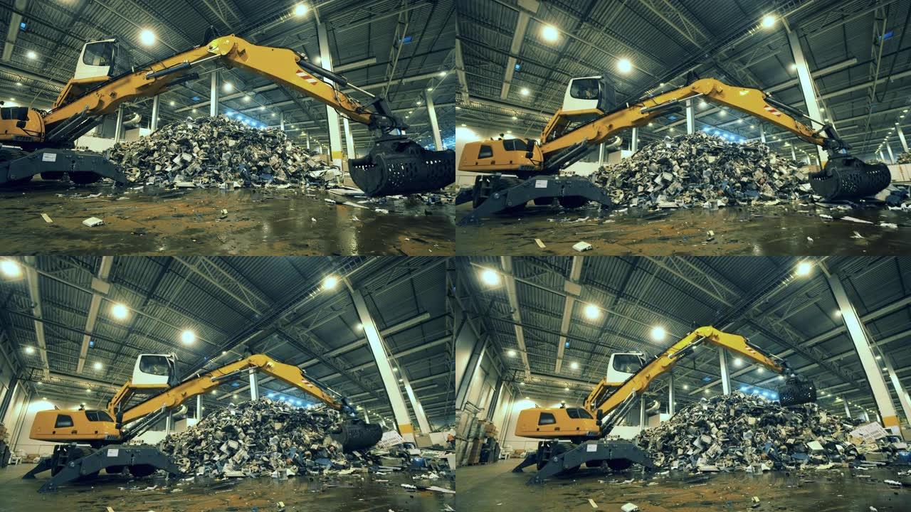 垃圾，塑料回收厂。工业装载机正在塑造一堆垃圾