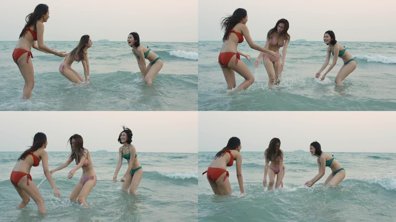 一群快乐的女孩朋友在海滩上玩水。暑假期间美丽的亚洲女孩。庆祝和放松的概念。