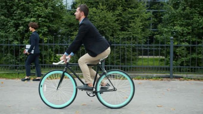 帅气经理活跃的人早上骑自行车去办公楼