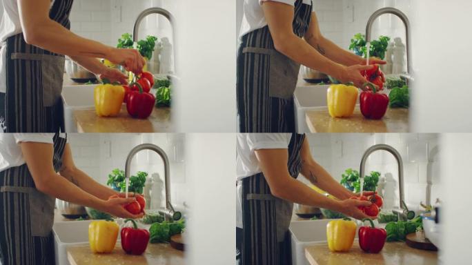 慢动作特写一名男子用自来水洗西红柿的镜头。正宗的时尚厨房配健康蔬菜。有机农业手工清洗的天然清洁产品。