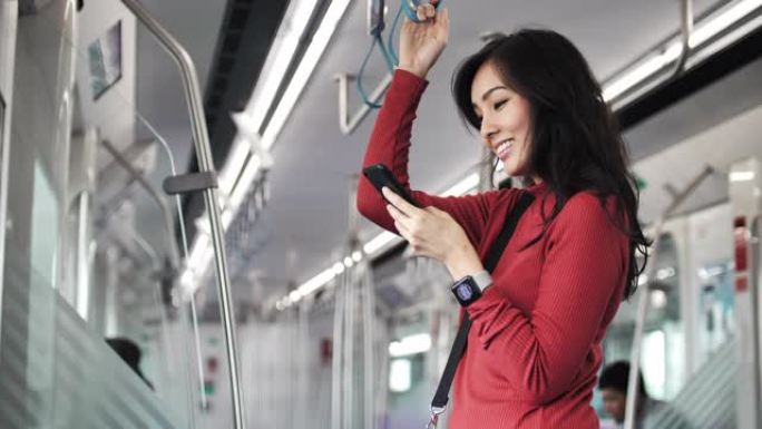 亚洲妇女在火车上使用智能手机