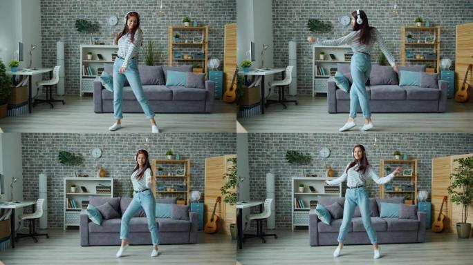 快乐的女人舞者戴着耳机独自在公寓里跳舞