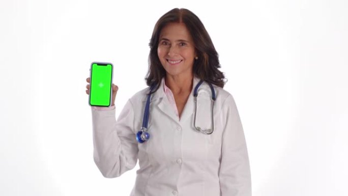 女成熟医生拿着智能手机可编辑屏幕，对着相机色度键微笑