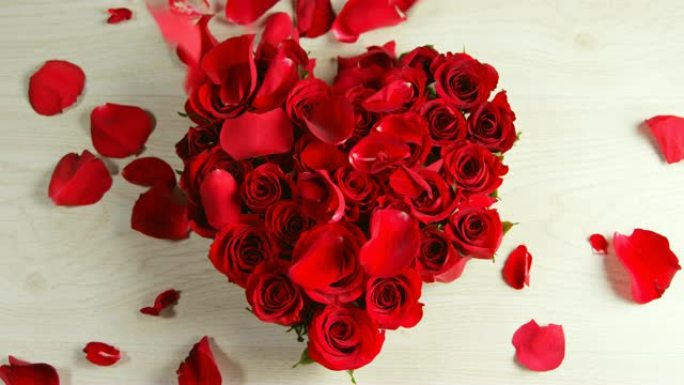 花瓣落在心形形成的红玫瑰上4k