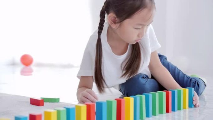 亚洲女孩在学校的地板上玩木制玩具积木。领导力，成就，教育，决心和未来，学前班，知识