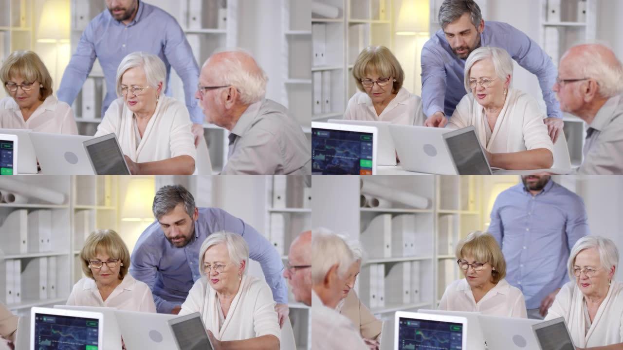 老师帮助在笔记本电脑上工作的老年人