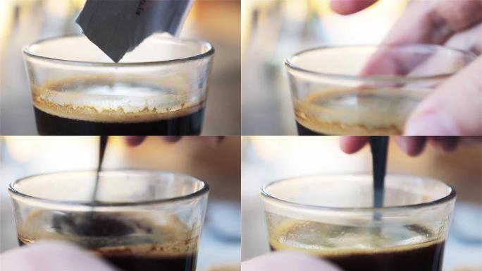 一勺糖即将被搅拌到一杯咖啡中。