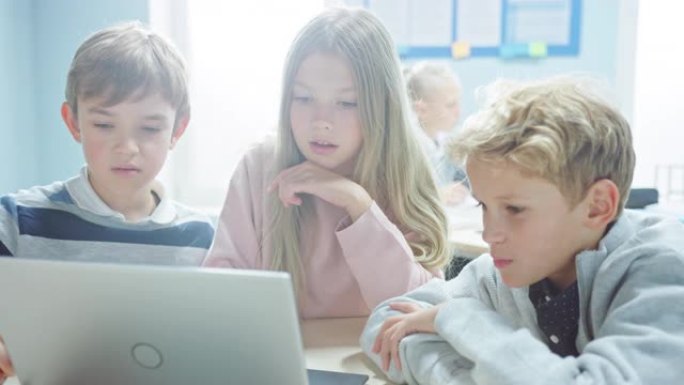 小学教室: 一群聪明的孩子使用笔记本电脑进行软件编程，交谈和团队合作。孩子们学习软件设计和创造性思维