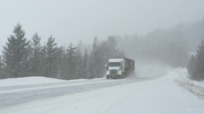 货运卡车引领其他车辆在暴风雪中行驶。