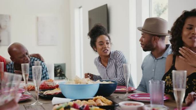 三代黑人家庭在家庭庆祝活动中坐在餐桌旁聊天