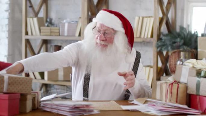 圣诞老人在办公桌前整理圣诞礼物