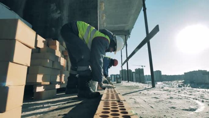 男工正在建筑地段用水泥修砖