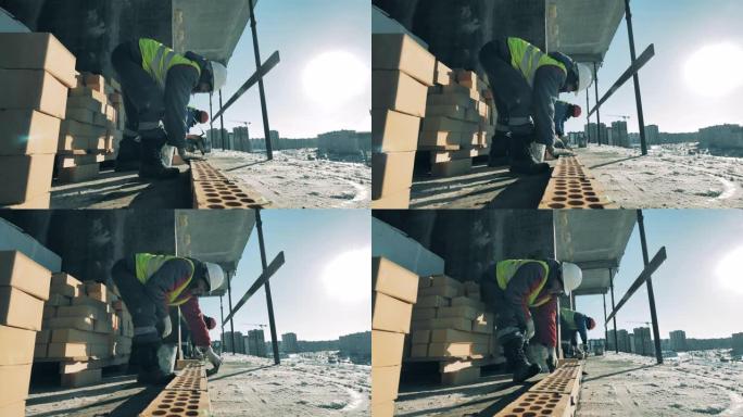男工正在建筑地段用水泥修砖