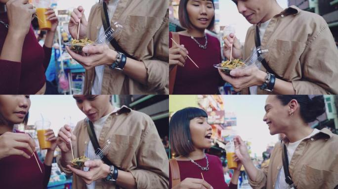 年轻的亚洲夫妇在曼谷考山路的街头食品市场购买被解雇的昆虫