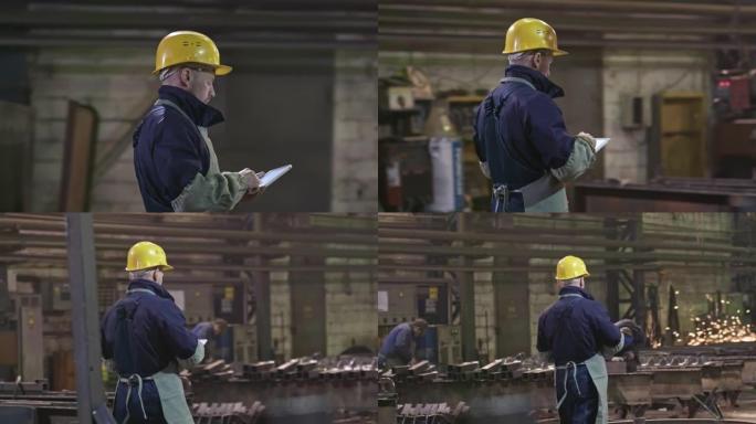 平板电脑穿过工厂的男性工人
