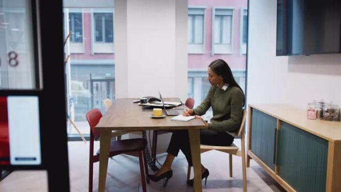 在会议室的办公桌上工作的女商人在笔记本电脑上工作
