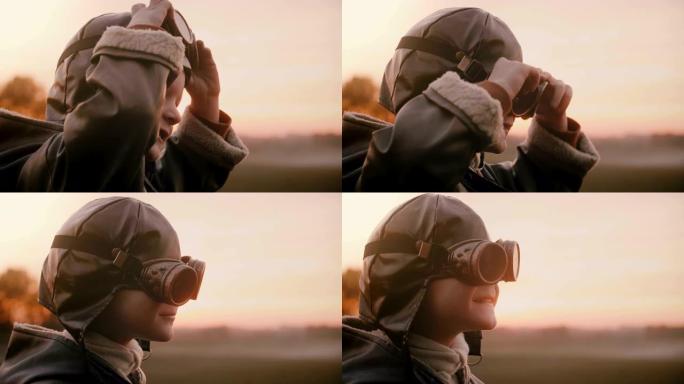 穿着旧飞行员服装的小男孩戴上复古航空眼镜，在日落场特写慢动作中微笑。