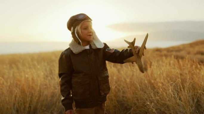 可爱的孩子穿着他的飞行服，驾驶他的木制飞机