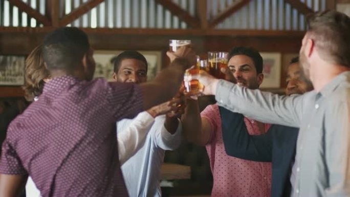一群男性朋友晚上在酒吧举行单身派对，一起敬酒
