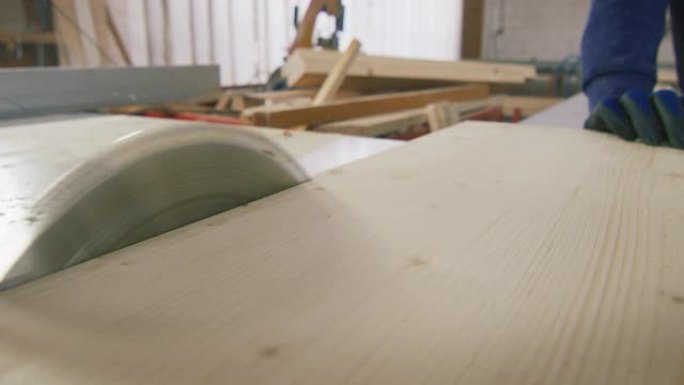 在一家木材工厂的车间里，从事木工机械工作的专业木匠的特写镜头。