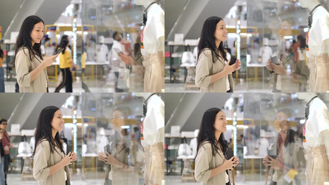 购物成瘾者亚洲妇女站在商店橱窗前