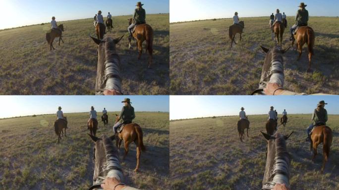 一群骑马者的慢动作视图，他们在Makgadikgadi盐盘的广阔空间中行走