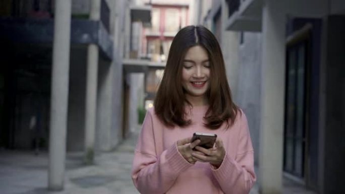 慢动作-亚洲旅游博主女人在中国北京唐人街旅行时，使用智能手机指引方向并在位置图上寻找。生活方式背包旅