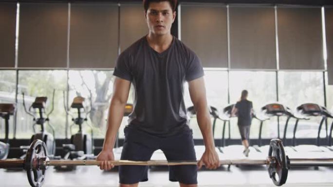 4K UHD: 年轻的亚洲男子在健身房用举重杠铃锻炼