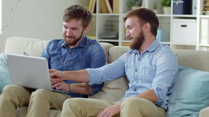 男性双胞胎使用笔记本电脑聊天