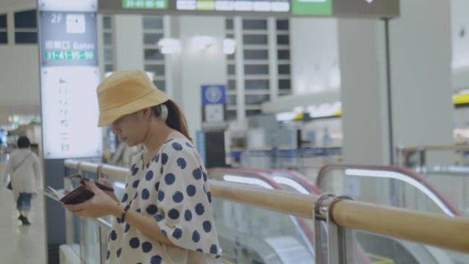 亚洲旅游妇女在机场使用手机。