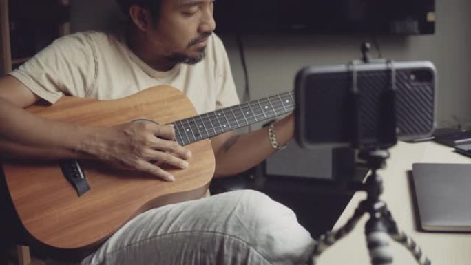 时髦的男人在网上用家里的视频教程上吉他课。